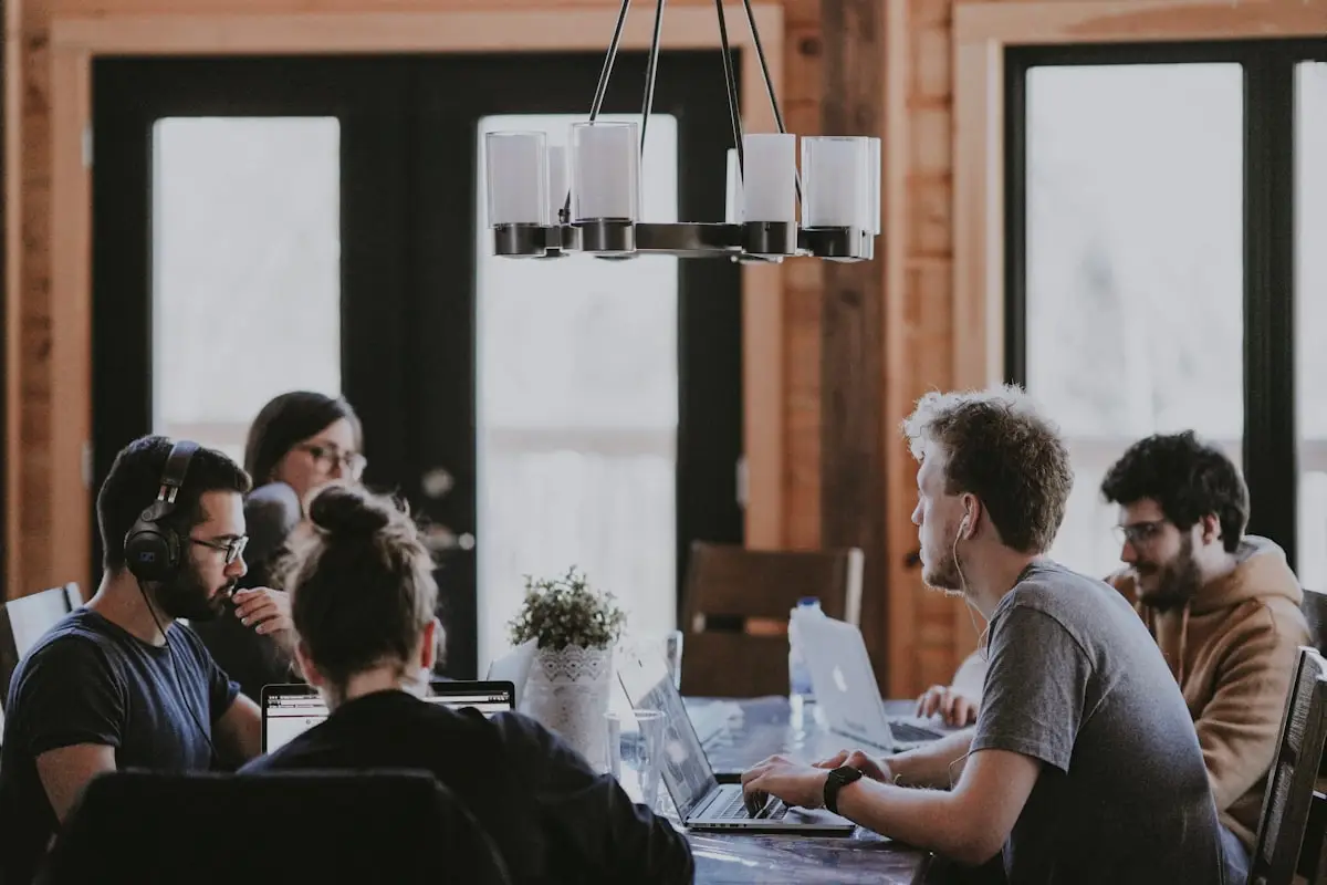 A team meeting around a table, several people on headsets